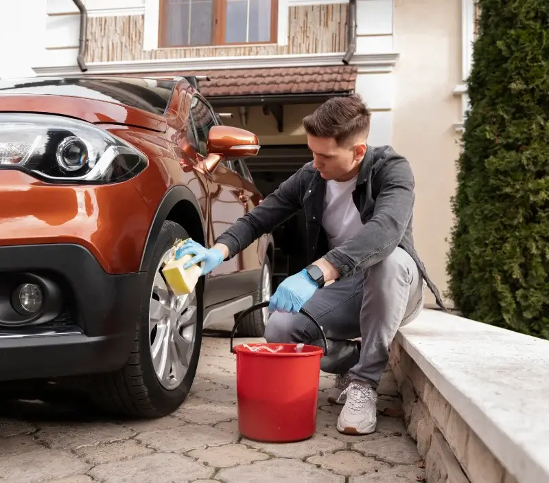 Lavage auto à domicile Saint-Julien-la-Genête : professionnel intervenant sur un véhicule